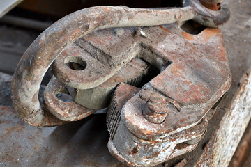 lifting hook with clip. Detail of a lifting machine with a clamping mechanism. old rusty hoist detail in an abandoned factory