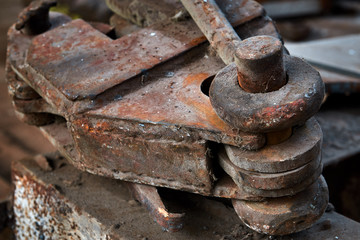 lifting hook with clip. Detail of a lifting machine with a clamping mechanism. old rusty hoist detail in an abandoned factory