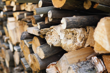Dry chopped firewood of solid pine and birch wood in a pile.