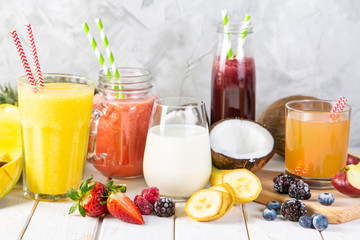 Selection of colourful smoothies in glasses with ingredients