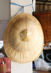 Hats made of palm leaves hung on pole