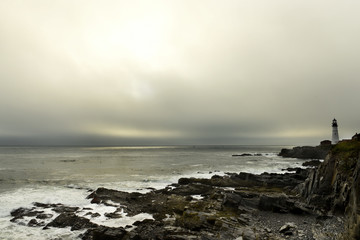 Lighthouse on the wild rocky shores of the Atlantic Ocean. USA. Maine. Portland. The oldest lighthouse of America.
