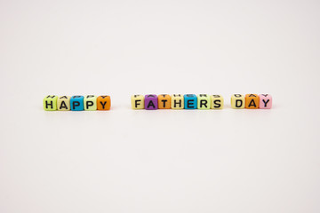Word happy fathers day assemble using colorful alphabet beads on a white background