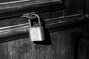 Old lock on a wooden door with rusty closed padlock, Vintage Black and white photo