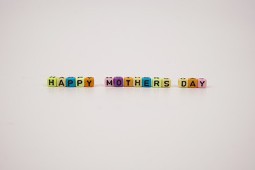 Word happy mothers day assemble using colorful alphabet beads on a white background 