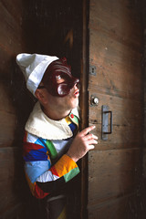 The mask of Arlecchino. Look out the door - obrazy, fototapety, plakaty