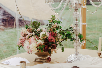 Luxury burgundy and pink flowers centerpiece. Elegant wedding event decor in marquee, outdoor.