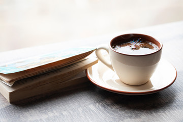 Cup of coffee with a book in coffee shop. Cozy concept 