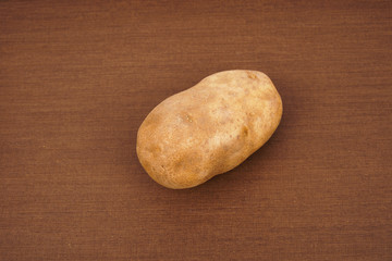 Russet potato with wooden texture background