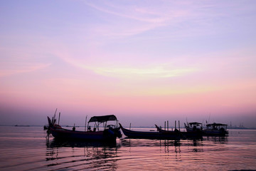 Sunrise at a bay of water and fishing port, the calm sea in low tide, a tranquil scene in morning mood