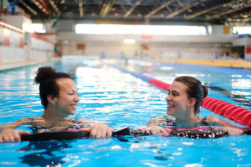 Multiracial couple attending water aerobics class in a swimming pool