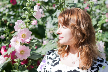 Fototapeta premium beautiful girl surrounded by colorful flowers mallow