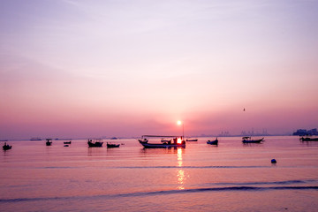 Beautiful sunrise on the beach and silhouette of fishing boat. Penang, Malaysia