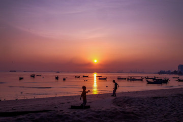 Silhouette of a boys enjoying the sunrsie at the beach in Penang Malaysia