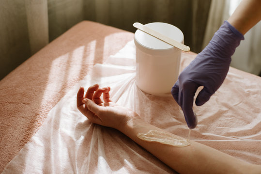 Hair removal on hands with sugaring. hot wax depilation procedure. close up. Beauty Concept