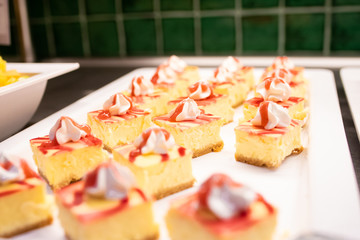 Tray of portions of cheesecake with strawberries