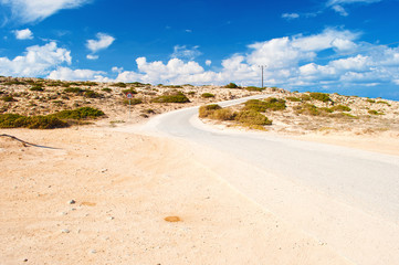 One round road sign with a number 30 near a winding asphalt road near Cape Greco