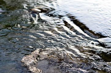 Close up of clean mountain  river water flowing over  rocks .