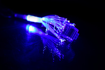 Network cable with fiber optics light on black background