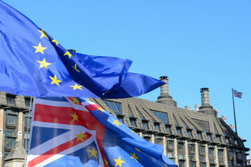 EU and UK flags flying together outside parliament in london