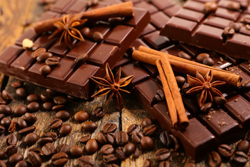 chocolate bar and spices on wood background