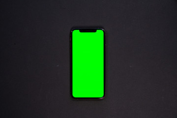 iPhone XS, smartphone, green screen on Black background top view