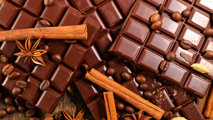 chocolate bar and spices on wood background