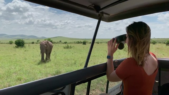 Woman on a safari trip in Masai Mara spotting elephants