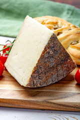 Italian cheese, piece of mature Tuscan Pecorino sheep cheese served with olive bread and tomatoes