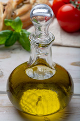 Virgin natural olive oil is glass bottle, served with traditional Mediterranean food