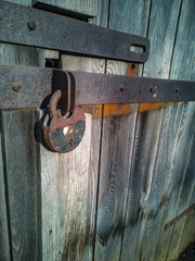 Old rusty door lock. Old locked wooden doors. Corrosion lock, obsolete boards.