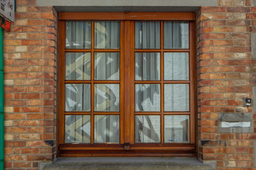 Brown wooden window on brick wall