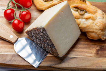 Italian cheese, piece of mature Tuscan Pecorino sheep cheese served with olive bread and tomatoes