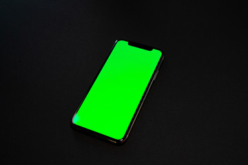 iPhone XS, smartphone, green screen on Black background top view