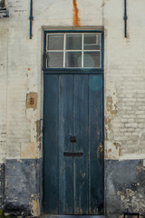 Typical building facade in Bruges, bricks and colorful door and window frames