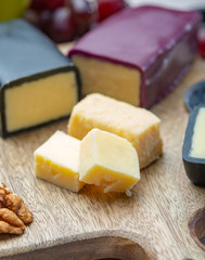 Mini black and dark red waxed cheddar cheeses made from West Country milk and and age-old methods in England