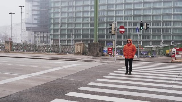 The guy is on a pedestrian crossing in the city Vienna in the fog