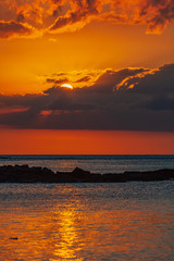 Obraz premium The burning sunset over Indian ocean paints water and sky in red color, Mauritius island