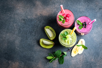 Fruit and berry smoothie blend at home against a dark background top view copy space.