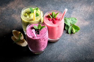 Fruit and berry smoothie blend at home against a dark background top view copy space.