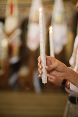 close up photo of the bride, groom holds in hands wedding candle. Burn candle. close up.