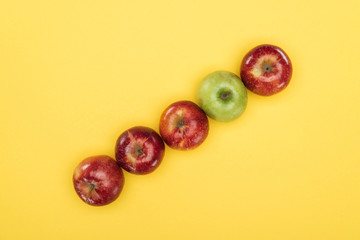 Fototapeta na wymiar Top view of ripe fresh apples on yellow surface