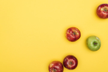 Top view of ripe fresh apples on yellow surface