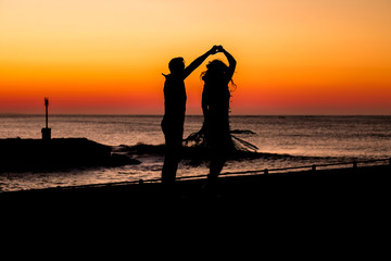 Couple dancing on the pier during sunrise make for awesome silhouettes