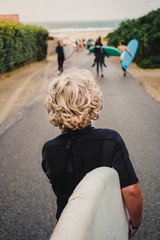 Junger Surfer auf dem Weg zum Strand im Surfcamp