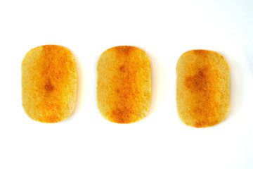 Tasty crispy potato chips on white background. Fast food snack.