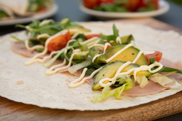 Cooking healthy avocado and vegetables burrito, wraps, rolles. Healthy breakfast or snack. Avocado sandwich. Copy space.