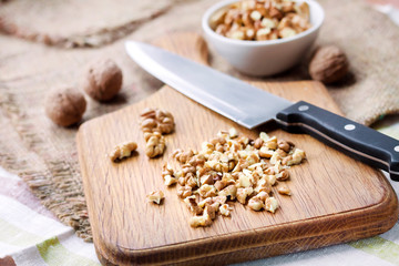 Fototapeta premium Chopped walnuts on wooden cutting board