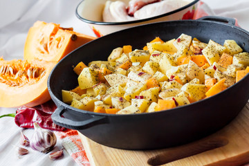 Cooking one-pot meal - chicken thighs and legs with potatoes and pumpkin