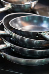 Fototapeta premium Several new metal pans shot close-up in the kitchen